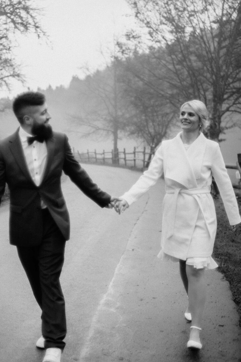 couple walking hand in hand in black and white