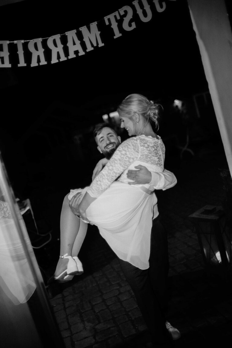 groom carrying bride in black and white vintage