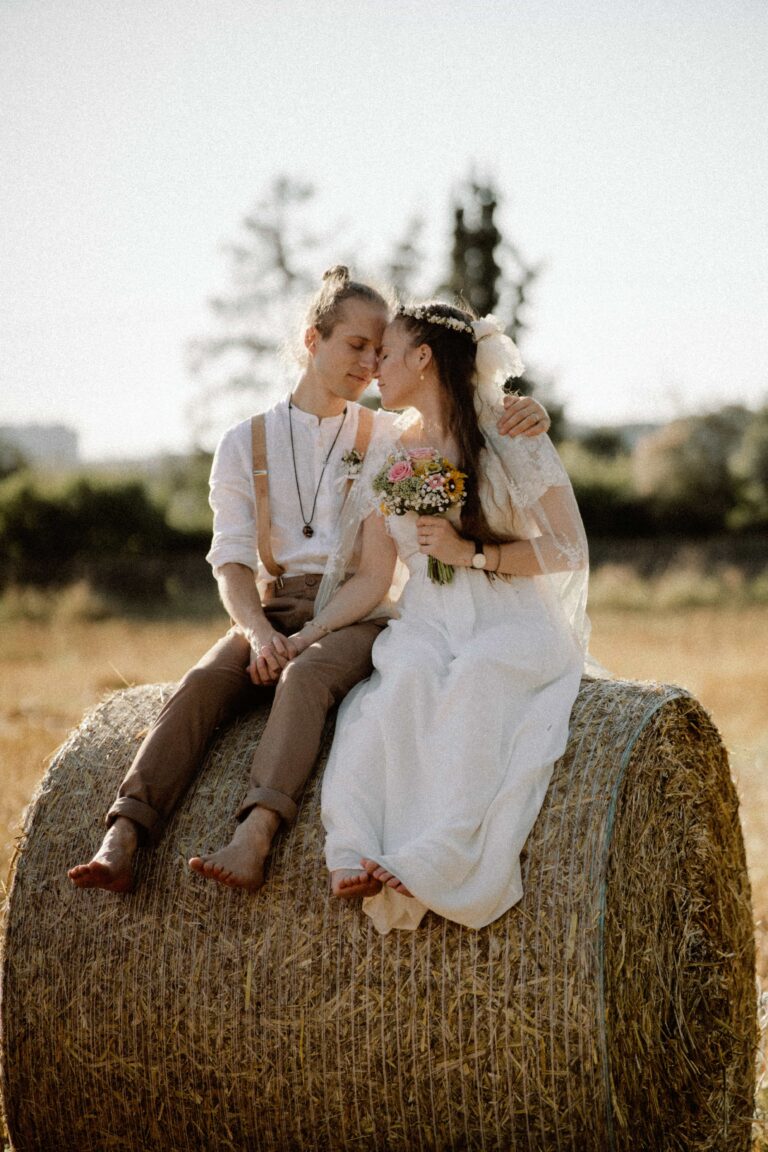 couple on straw bale in warm summer analog tones