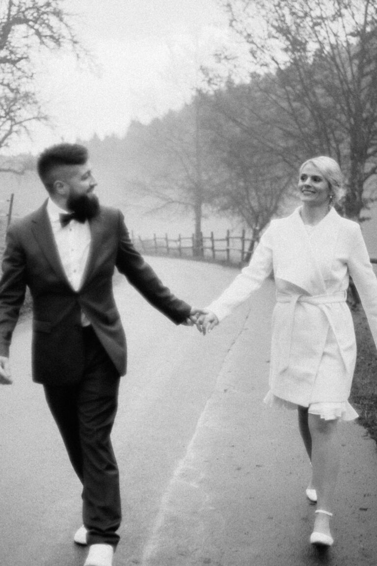 couple walking hand in hand in black and white