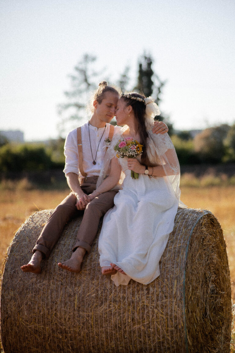 couple on straw bale in warm summer analog tones