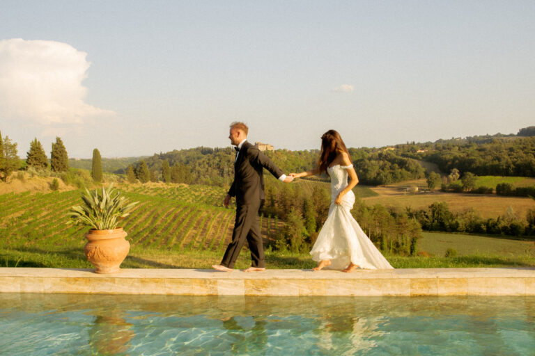 bride and groom walking by pool